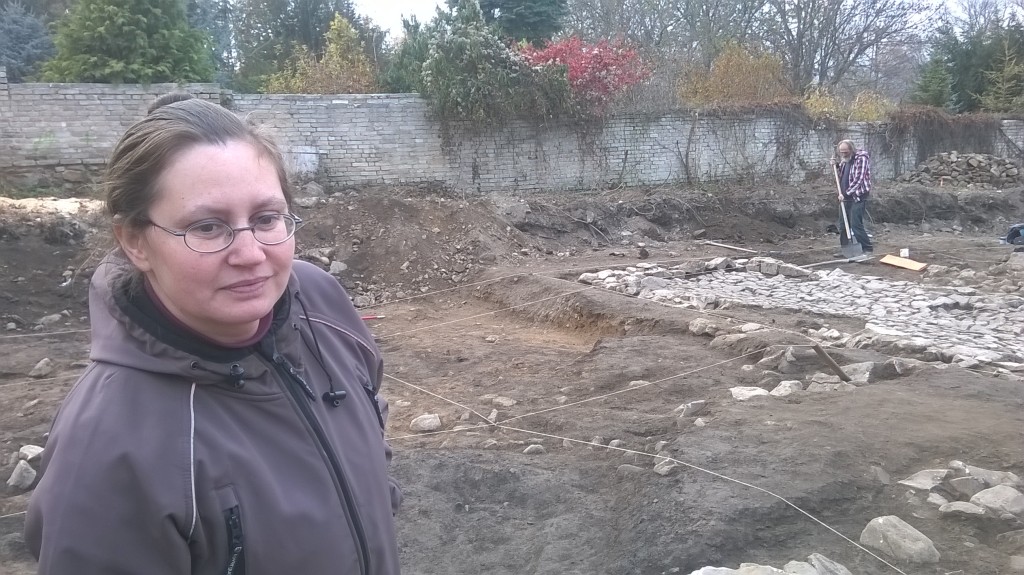 Petra Zemanová z Archeologického ústavu památkové péče Středních Čech. Za ní je vidět dlažba chlívku z 19.století 