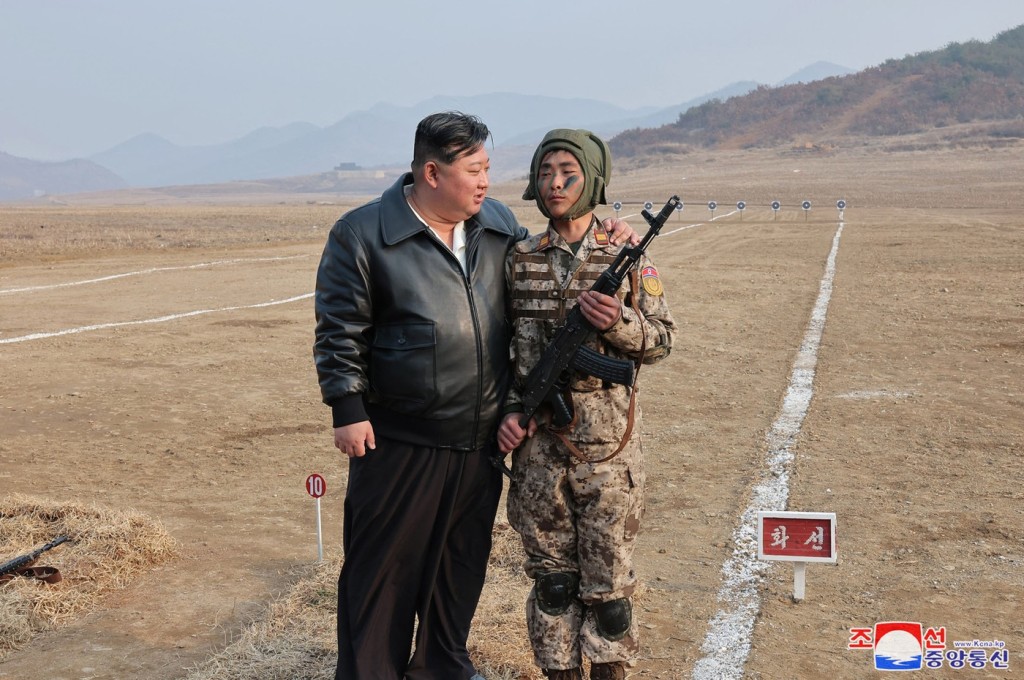 Kim Čong-un povzbuzuje jednoho z vojáků v průběhu cvičení