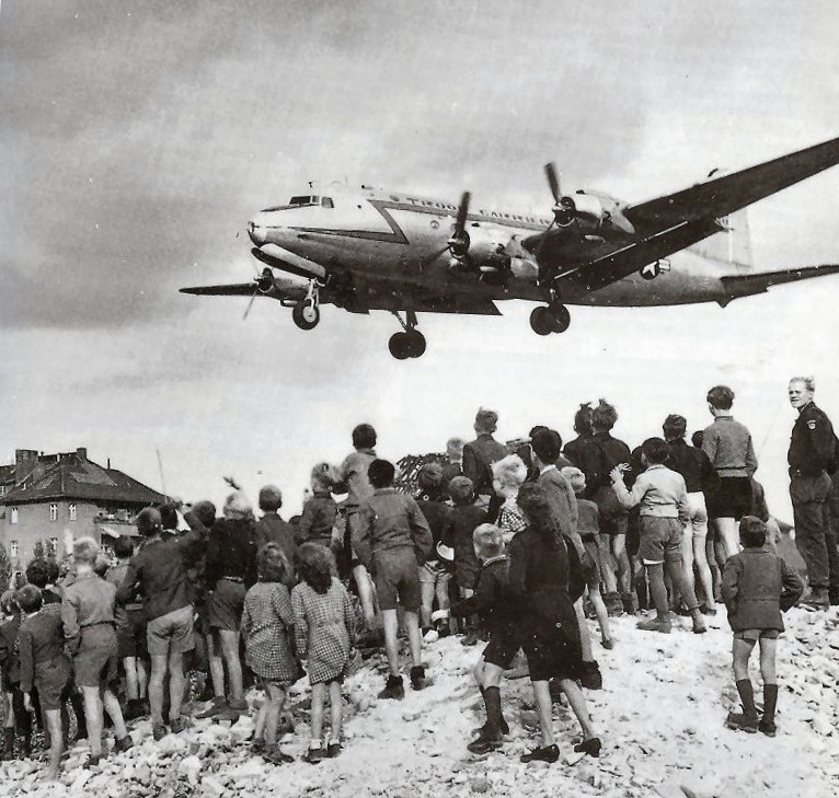 Obyvatelé Berlína sledují letoun Douglas C-54 Skymaster operující v rámci leteckého mostu do jejich města